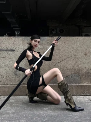Distressed shaft stiletto boots styled with a black streetwear outfit in an industrial outdoor setting