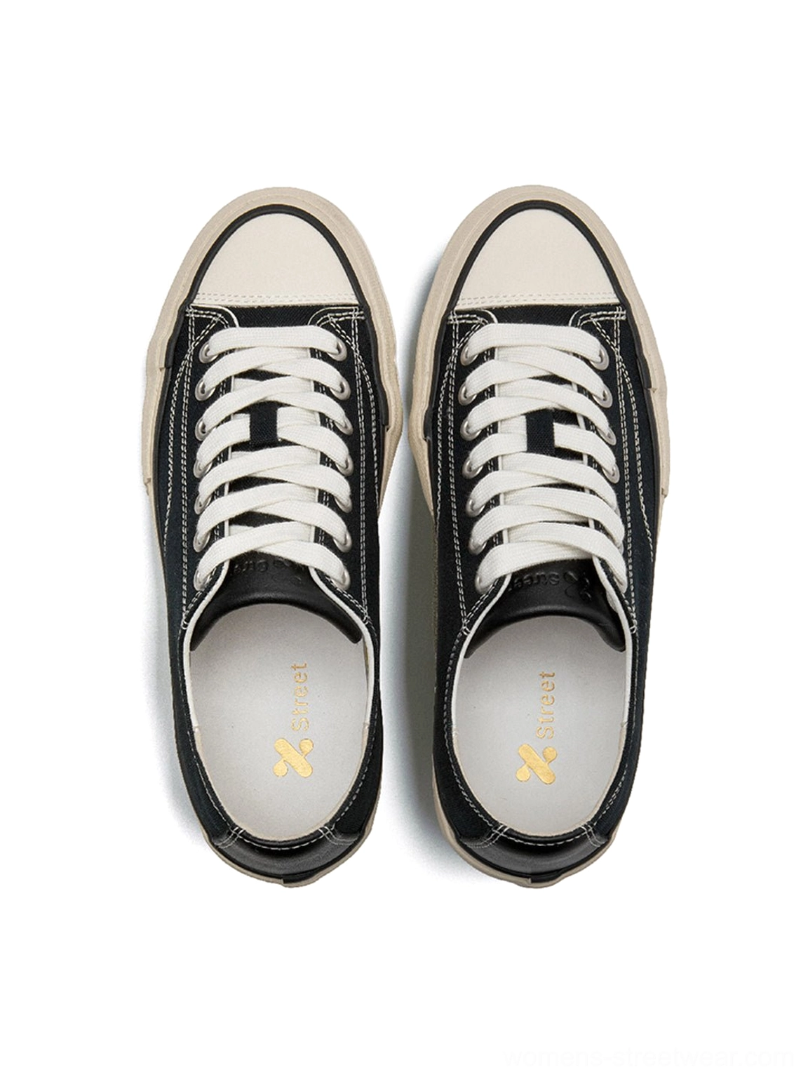 Top-down flat lay of black canvas platform sneaker pair with white laces, branded golden logo insole, and thick off-white cork midsole