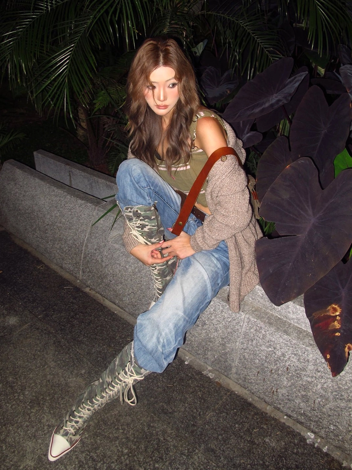 Model wearing camouflage corset lace-up knee-high stiletto boots with layered denim and Y2K streetwear styling