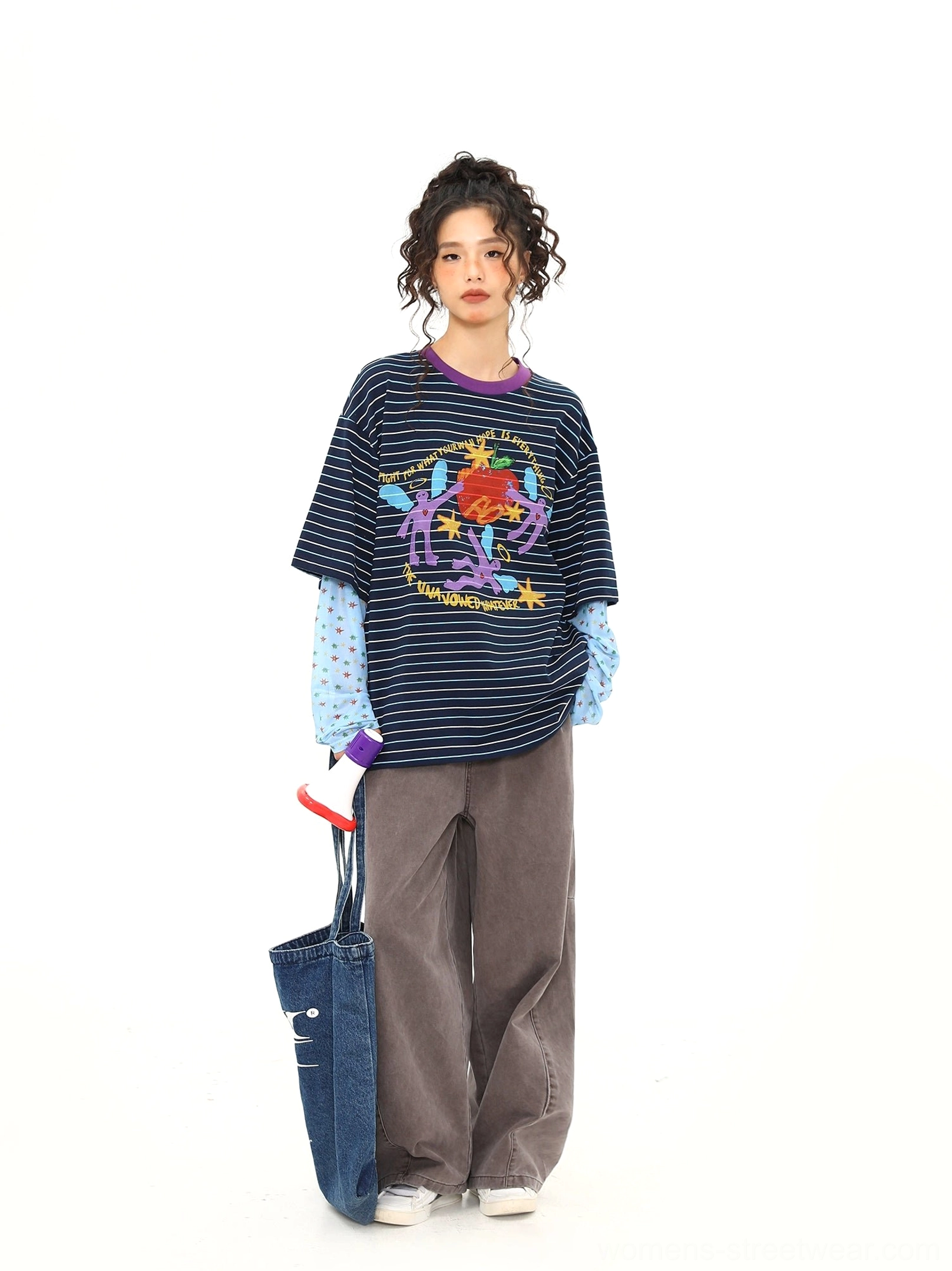 Blue striped fake two-piece long sleeve streetwear tee styled with dark brown wide leg pants and denim tote bag, full outfit side view