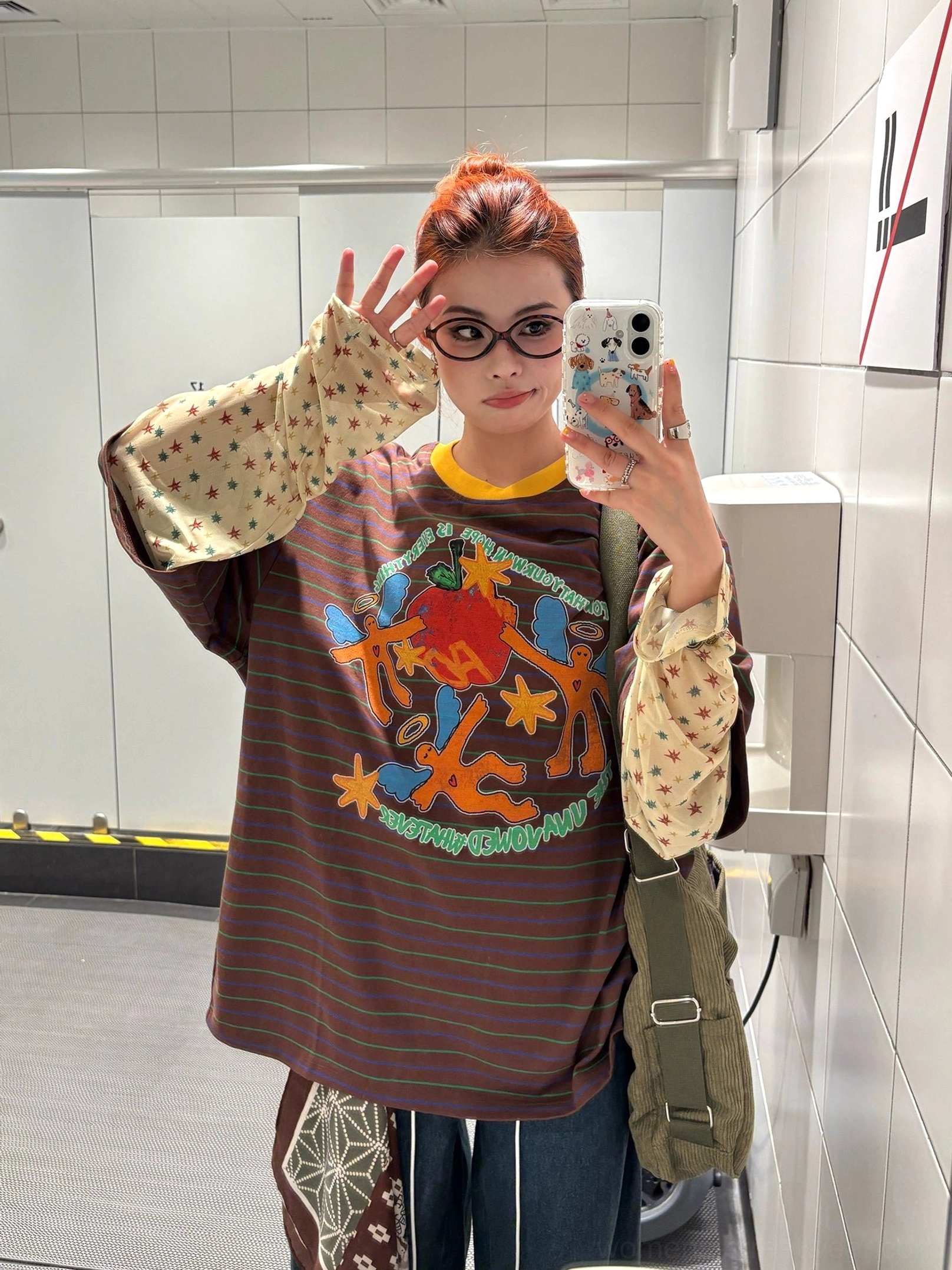 Brown striped fake layered long sleeve streetwear top with vintage graffiti chest print, yellow collar, and beige polka dot sleeves in mirror selfie styling