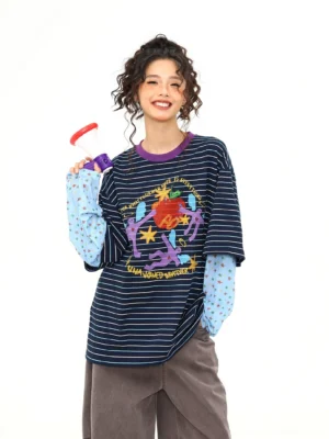 Blue striped fake two-piece long sleeve streetwear tee with colorful cartoon graffiti graphic, contrasting purple collar, polka dot inner sleeves, and oversized relaxed fit