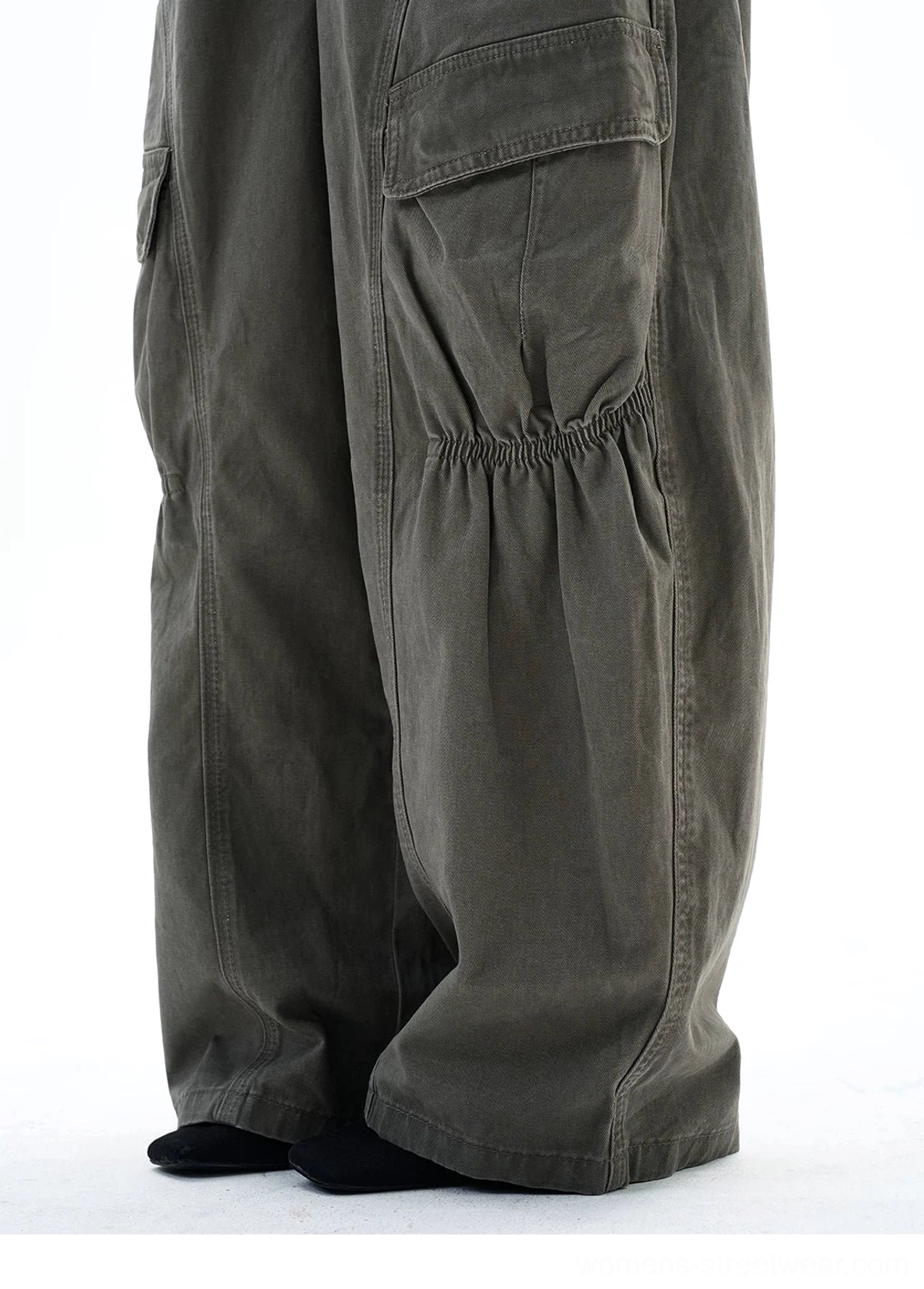 Close-up of gathered knee detailing and structured side cargo pocket on 100 percent cotton washed gray-green streetwear pants