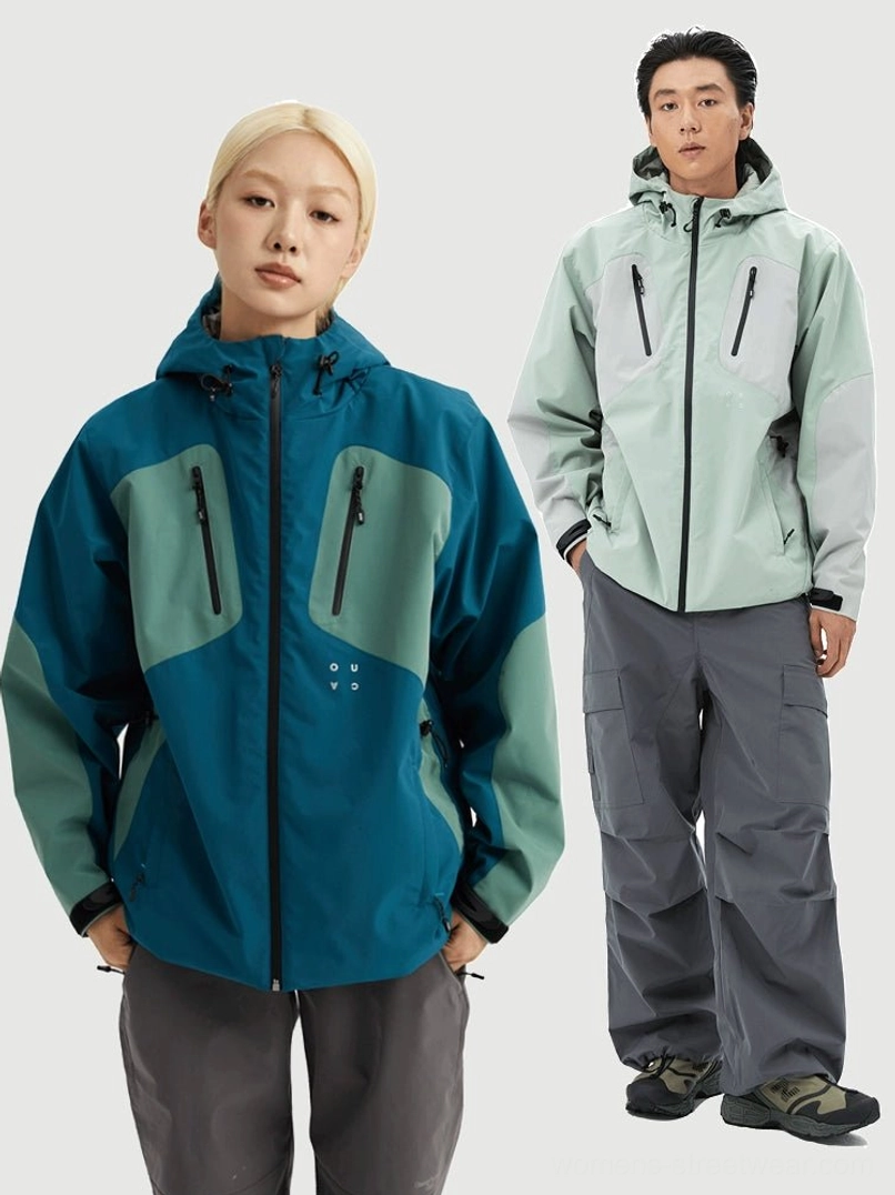 Couple wearing coordinated teal and mint grey color block outdoor hooded jackets with chest zipper pockets