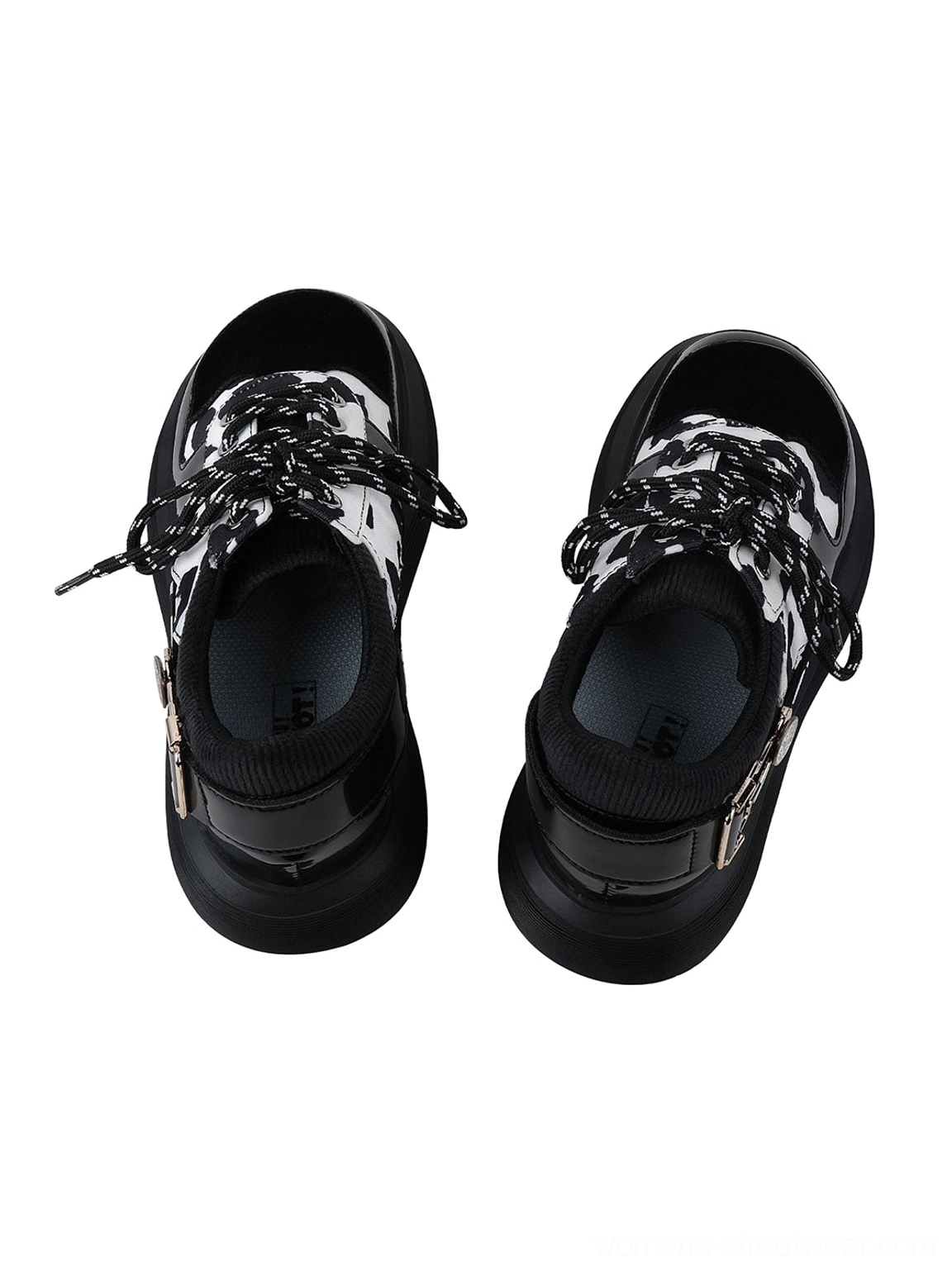 Women's cow print platform Mary Jane shoes with rounded toes, glossy black panels, decorative buckles, and elevated block soles