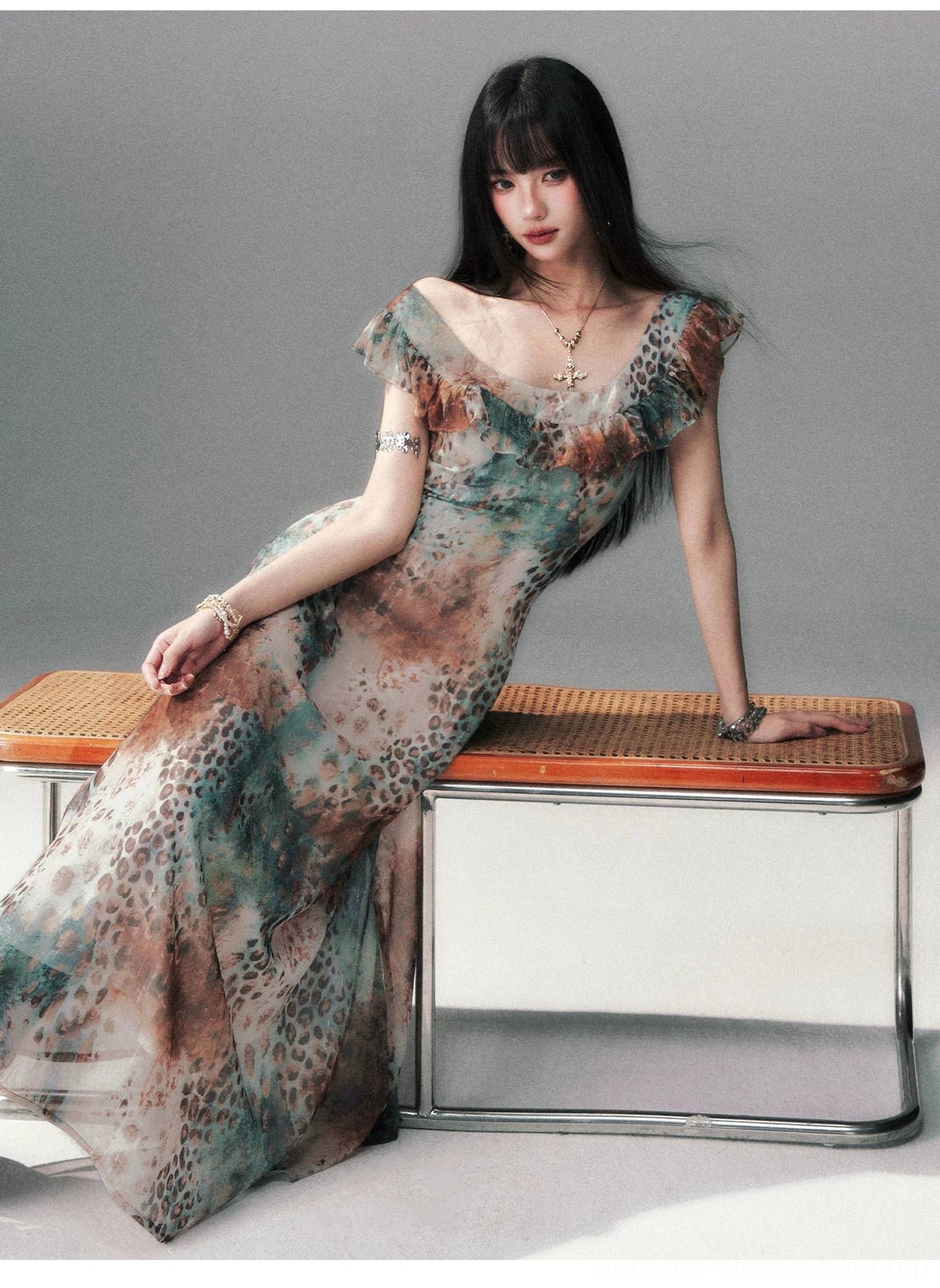 Three-quarter view of a watercolor leopard maxi dress with cowl neckline, ruffled sleeve trim, fitted waist, and flowing floor-length skirt