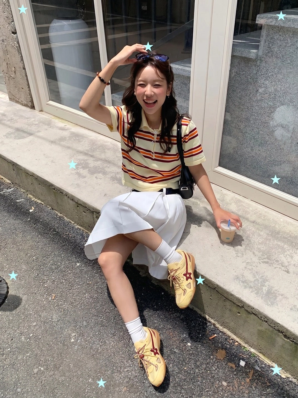 Cream burgundy star retro running sneakers worn outdoors with a casual feminine streetwear outfit in sunlight