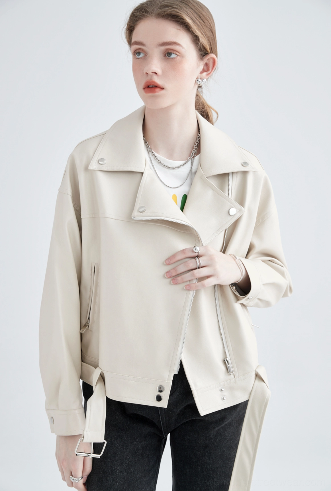 Close-up of cream faux leather moto jacket asymmetric zipper shoulder tabs and adjustable side waist strap