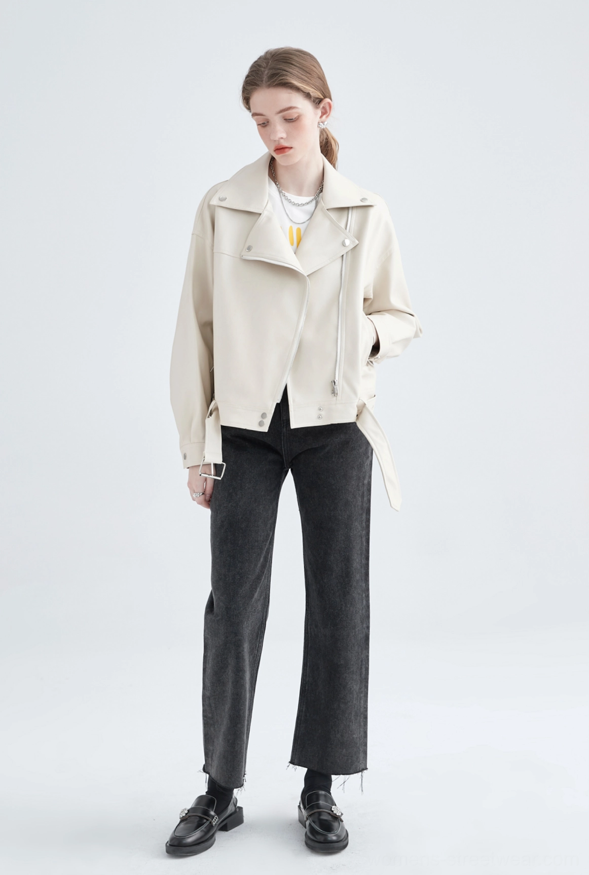 Side back view of cream faux leather cropped moto jacket showing clean back panel and adjustable waist belt