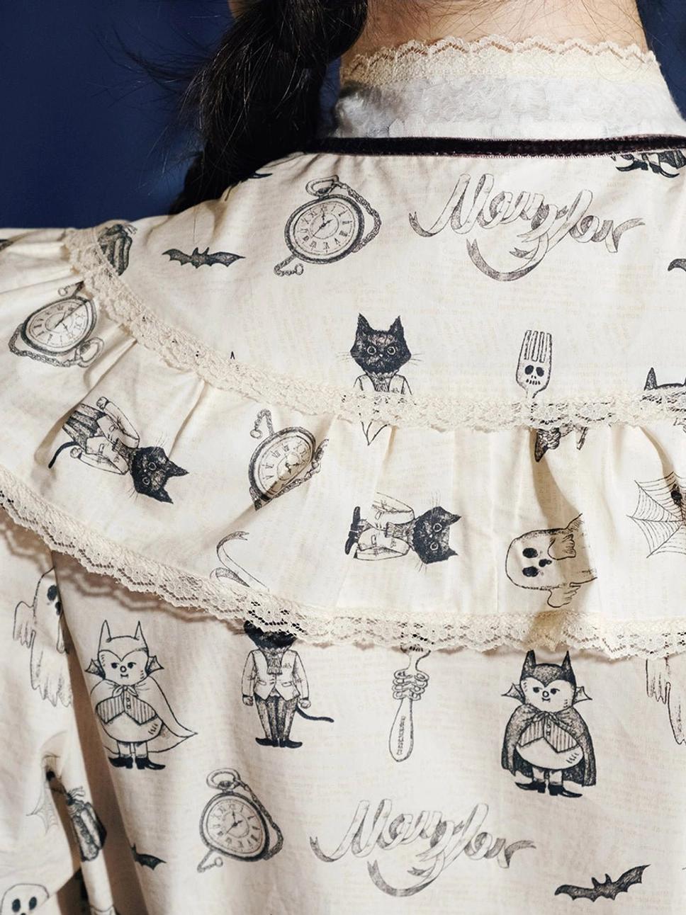 Back detail of cream Victorian Gothic Lolita ghost print dress with lace-trimmed yoke, black velvet ribbon, cats, bats, and pocket watch print