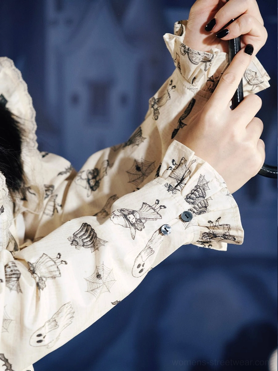 Close-up of ruffled long sleeve cuff on cream ghost print Victorian Gothic Lolita dress with black shell button detail