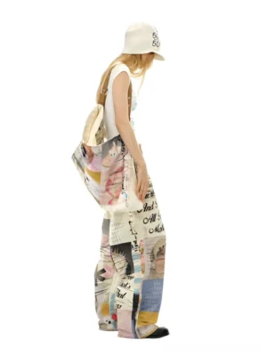 Side view of relaxed cream graphic baggy jeans with cartoon dog patchwork print styled with a cropped top and coordinated streetwear tote bag