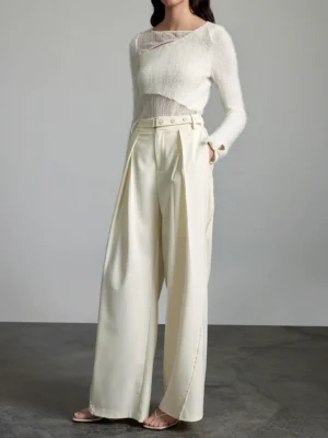 Front three-quarter view of cream high-waisted wide-leg streetwear trousers with pleats, belt loops, and tailored silhouette