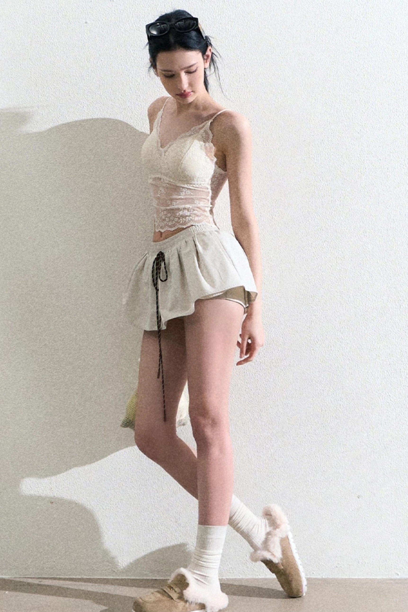 Low angle view of a cream lace sheer camisole outfit styled with crew socks and loafers
