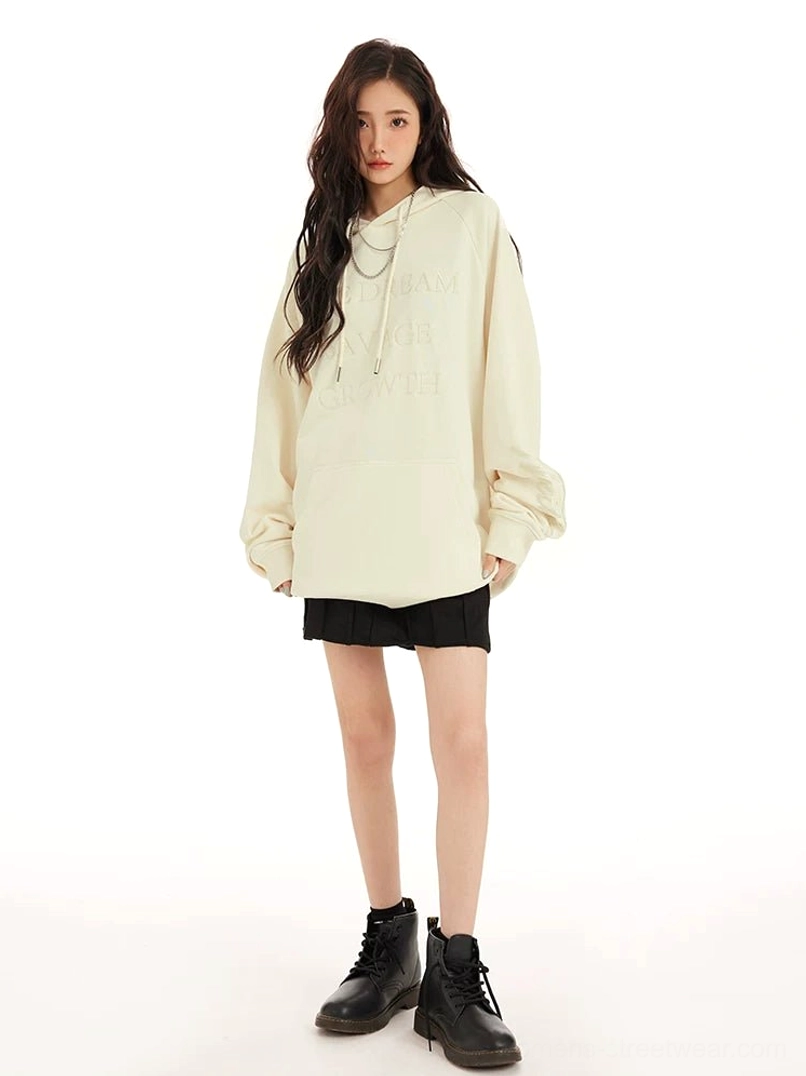 Cream oversized embossed lettering hoodie styled with a pleated mini skirt and combat boots for a Korean streetwear outfit