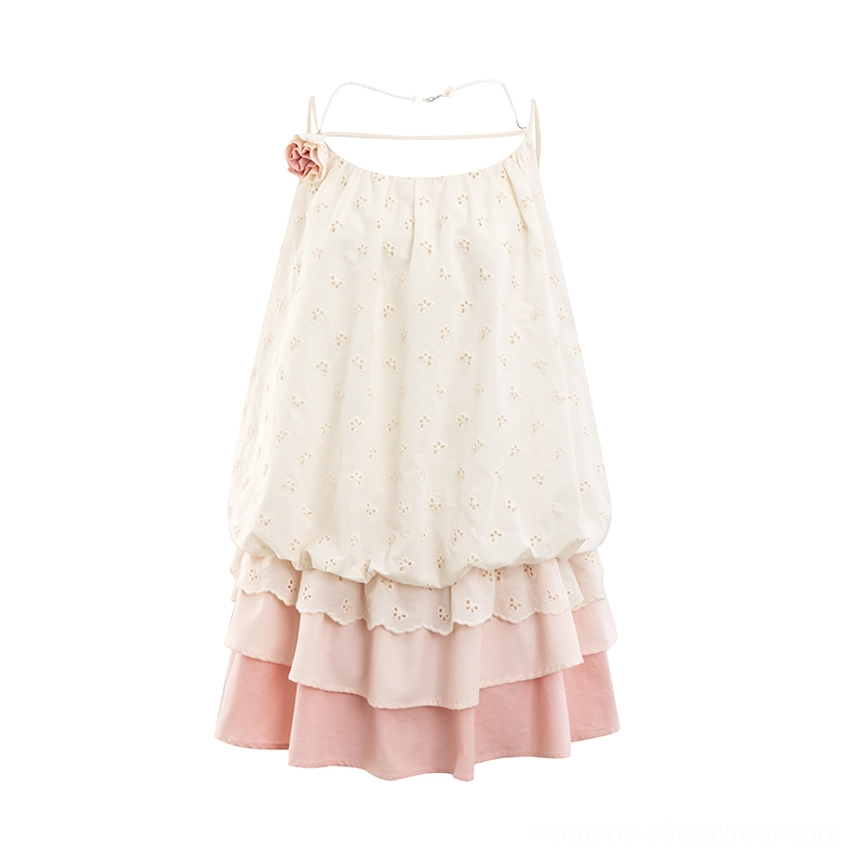 Flat lay hanging view of cream embroidered floral mini slip dress with square open back, pink layered ruffle hem, and fabric flower strap accent