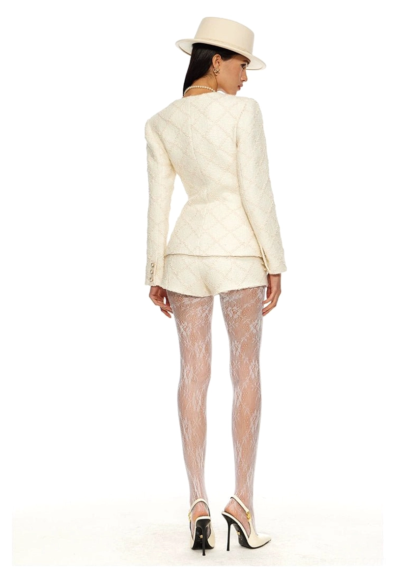 Cream quilted tweed two-piece suit shown from the back with tailored blazer hem matching mini shorts and lace tights