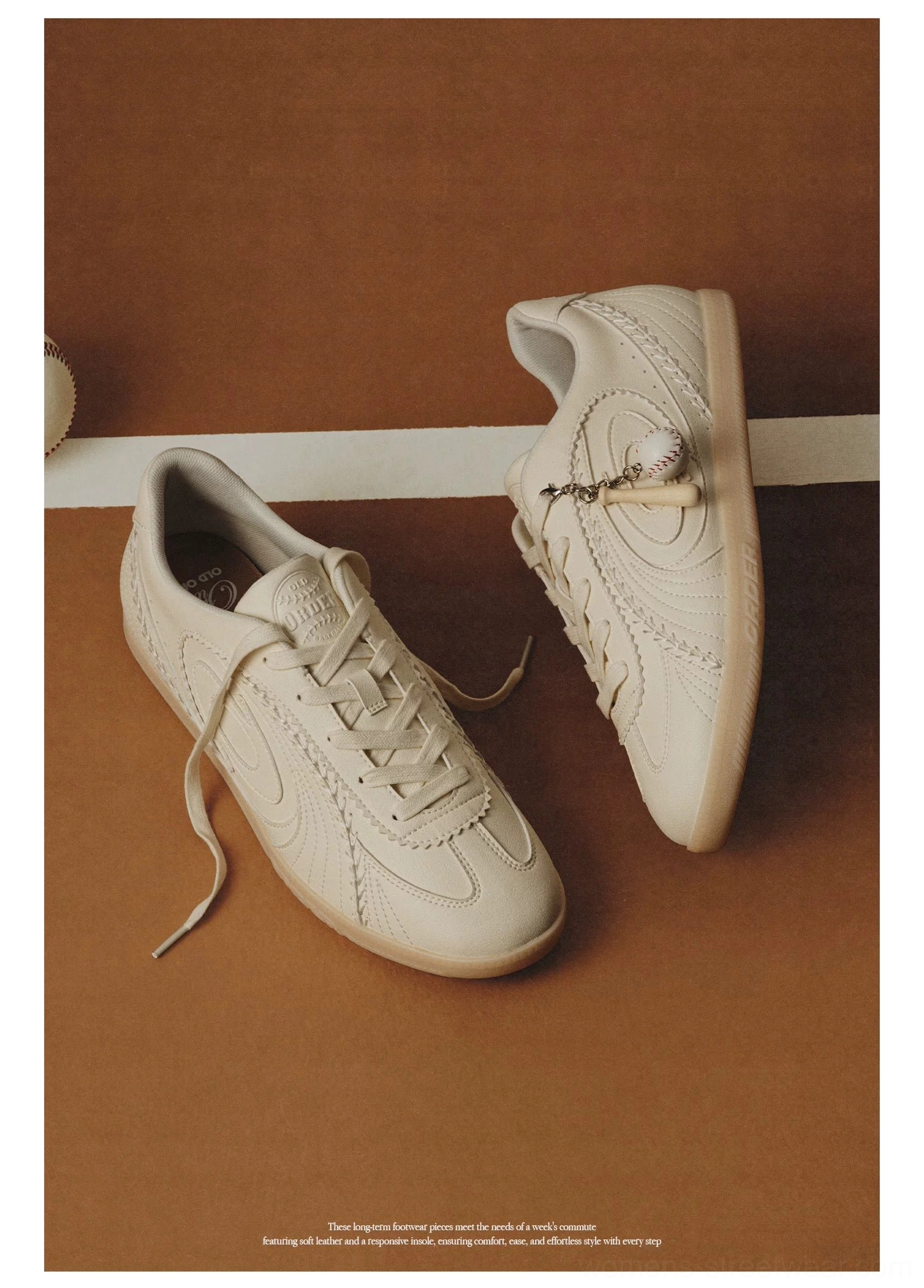 Top-down flat lay of cream retro training sneakers with classic gum rubber sole and pom-pom lace charm