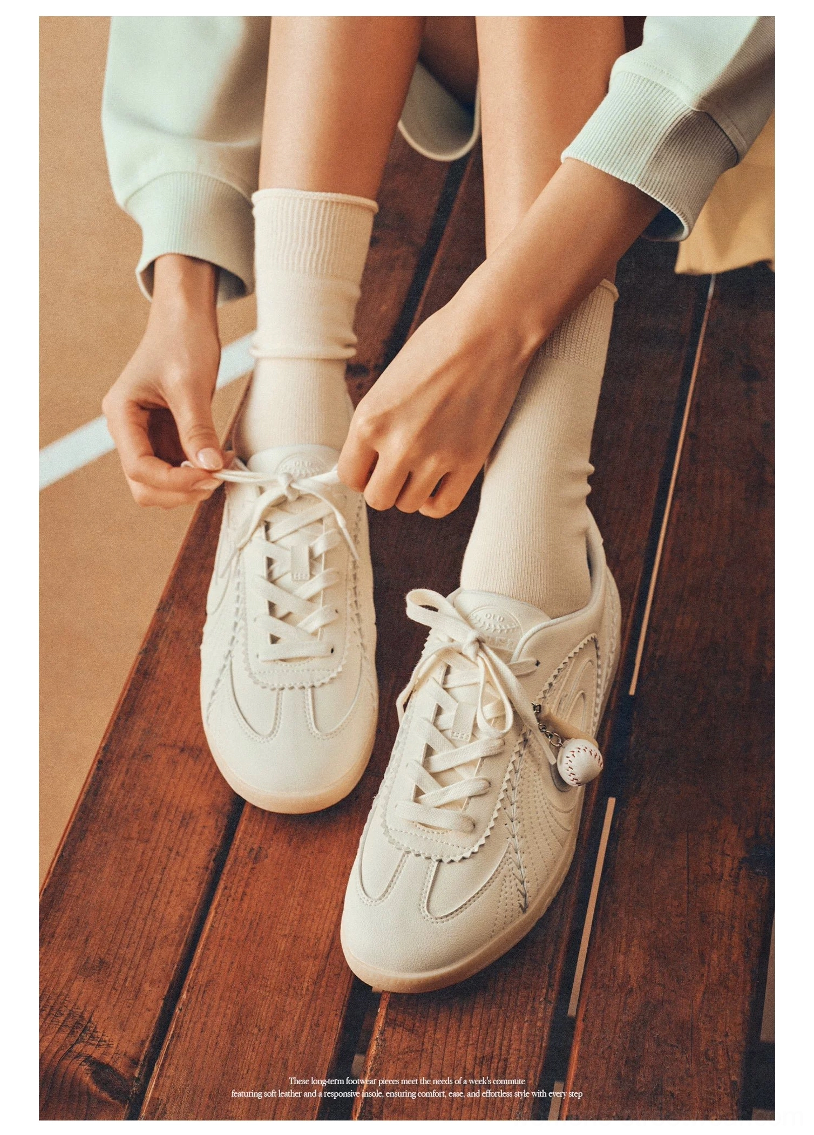 Top view of cream retro training sneakers with lace-up closure gum sole and pom-pom lace accent