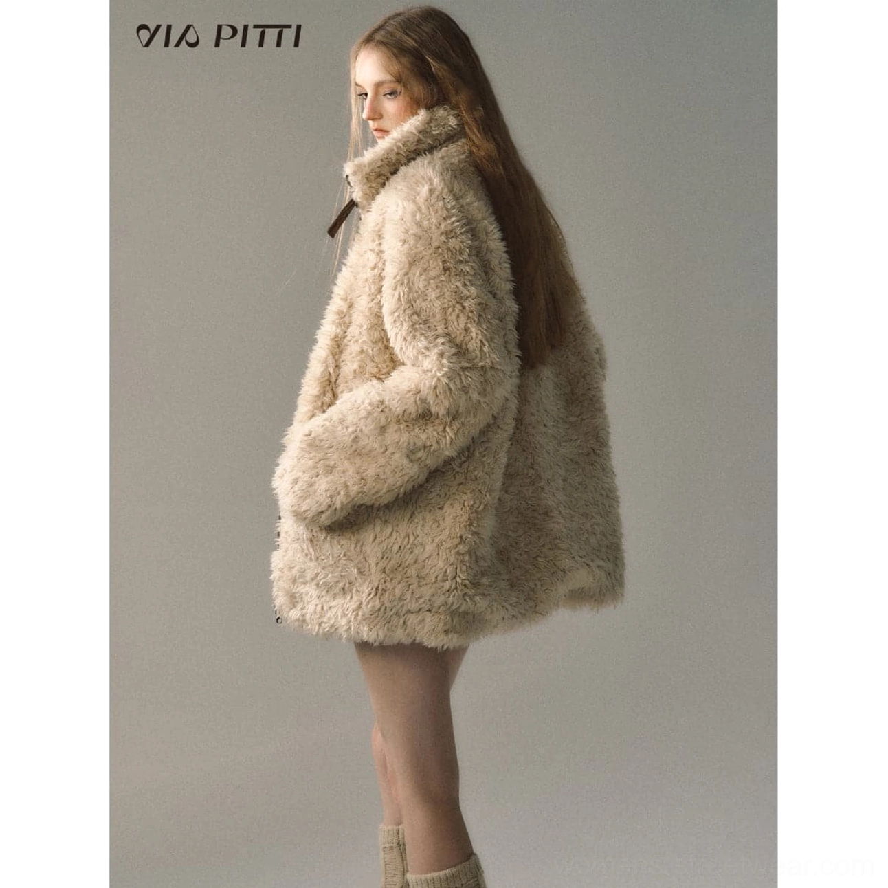 Reverse cream fleece side of an oversized reversible suede shearling jacket shown in a relaxed full-body streetwear outfit