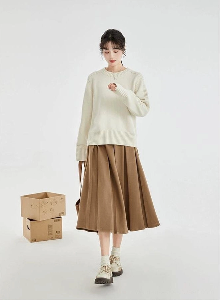 Full body side view of a cream ribbed drop-shoulder sweater paired with a brown pleated skirt and vintage leather shoes