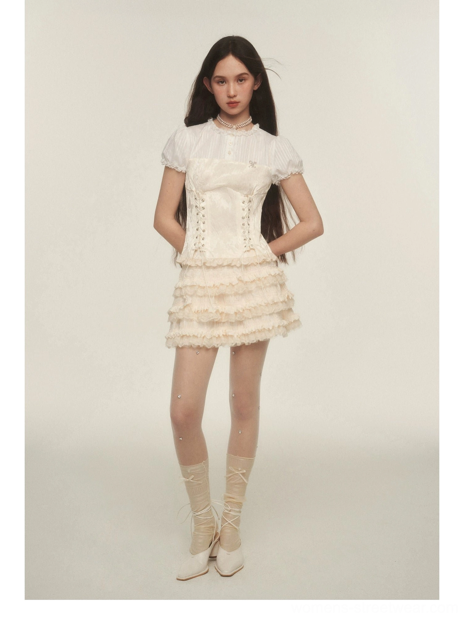 Side view of a cream ruffle mini skirt outfit with sheer rhinestone stockings and coordinated lace-up mid-calf socks