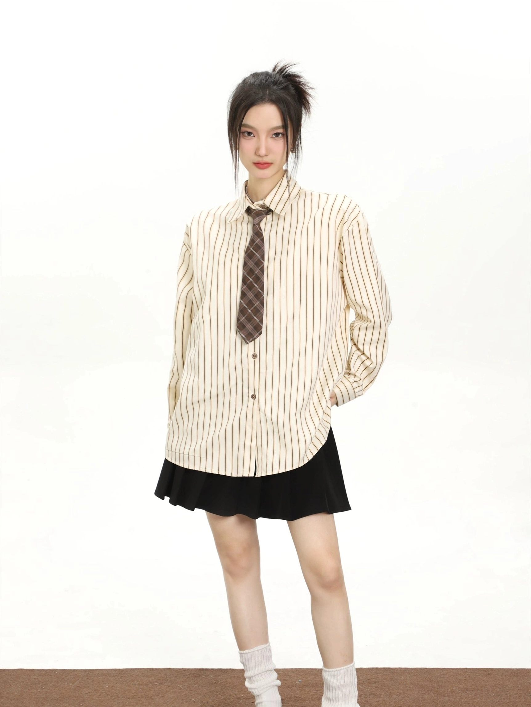 Cream white striped women's long sleeve shirt with brown tie black pleated skirt and white crew socks