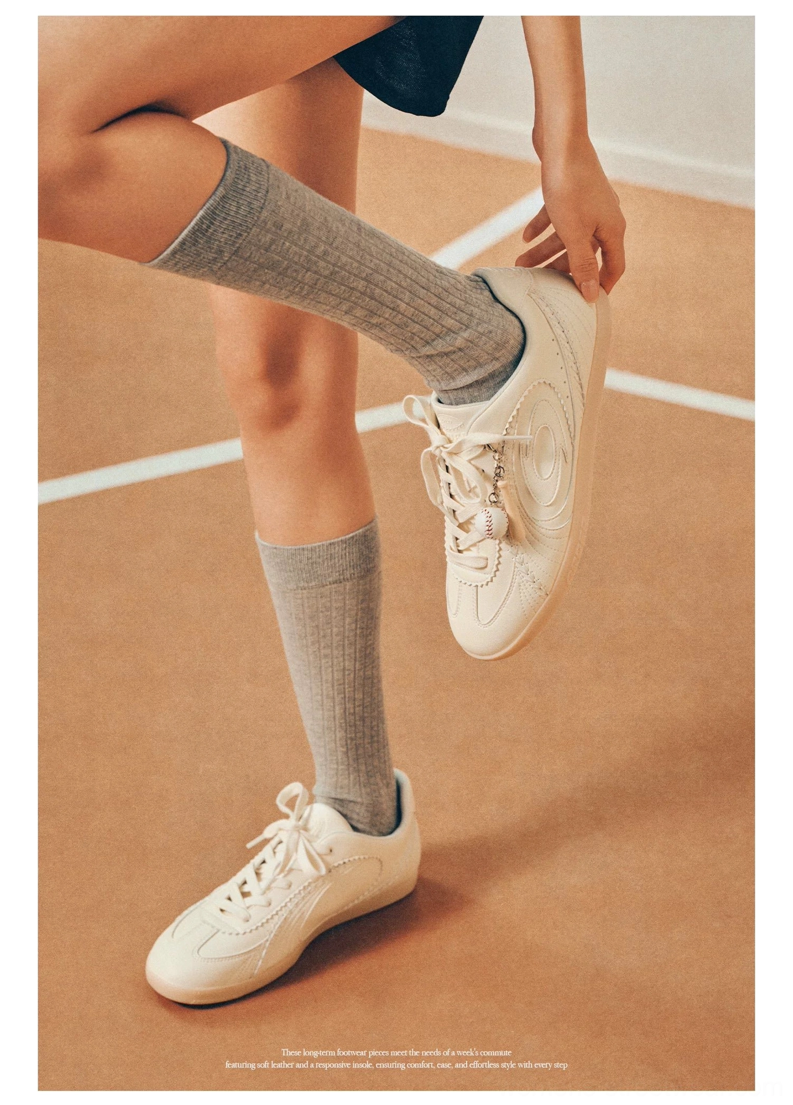 Side view of cream vintage court sneakers with low-profile silhouette worn with grey crew socks