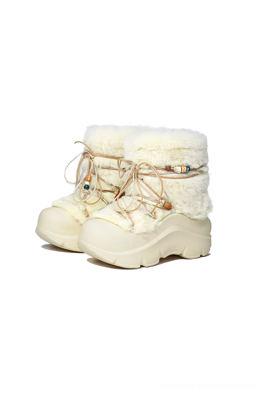 Pair of cream white faux fur beaded snow boots displayed side by side with chunky platform soles and decorative laces
