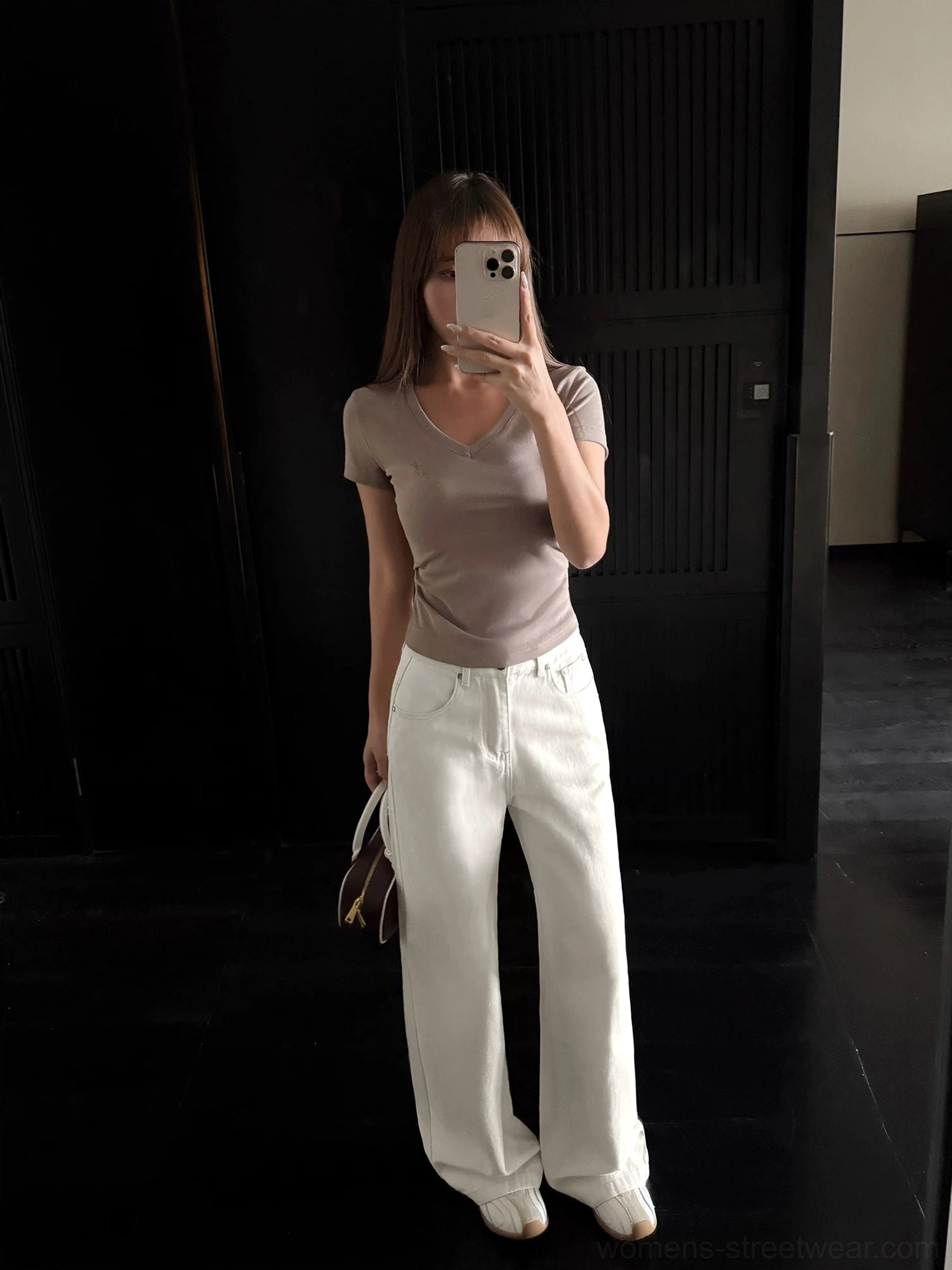 Mirror selfie showing relaxed cream wide-leg denim streetwear pants styled with a taupe short-sleeve tee heels and a small handbag