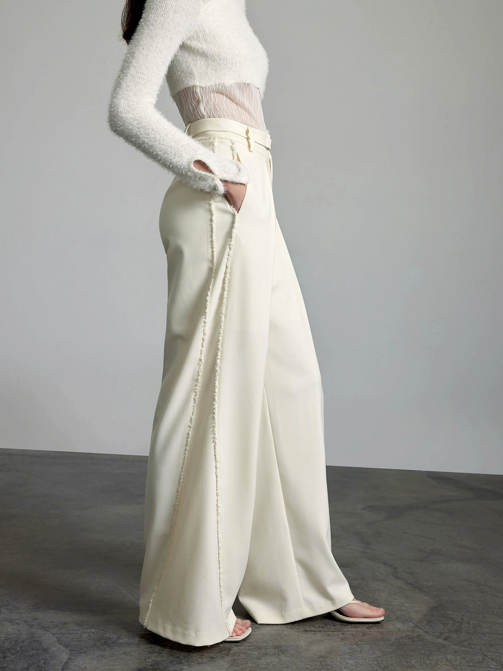 Right side profile of cream wide-leg trousers featuring decorative outer-leg stitching and relaxed streetwear styling