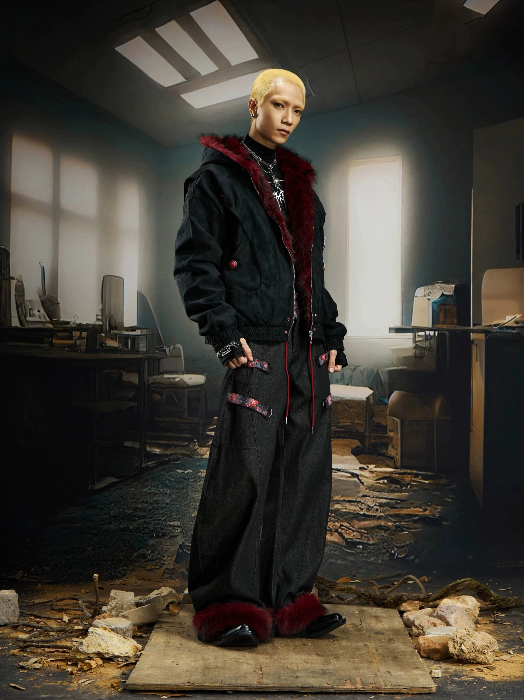 Male side profile wearing black faux fur hood bomber jacket styled half zipped with dark wide leg cargo pants