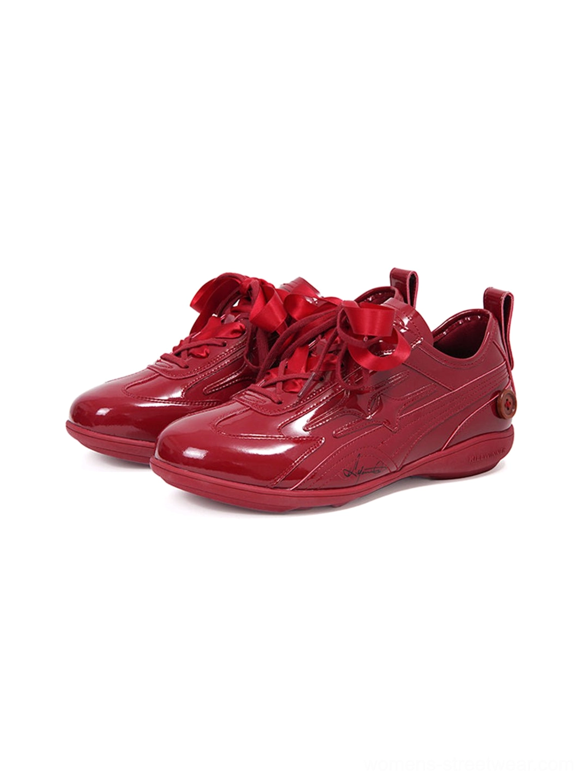 Side three-quarter studio view of paired crimson gloss athletic retro runner sneakers in vivid red