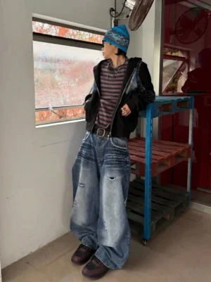 Male streetwear model wearing crimson and black Jin Yi Wei inspired embossed low-top sneakers in an industrial indoor setting