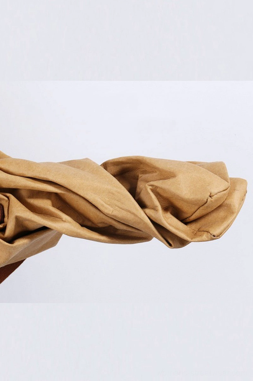 Close-up of warm tan crinkled kraft paper effect cotton fabric texture used for the foldable minimalist tote bag