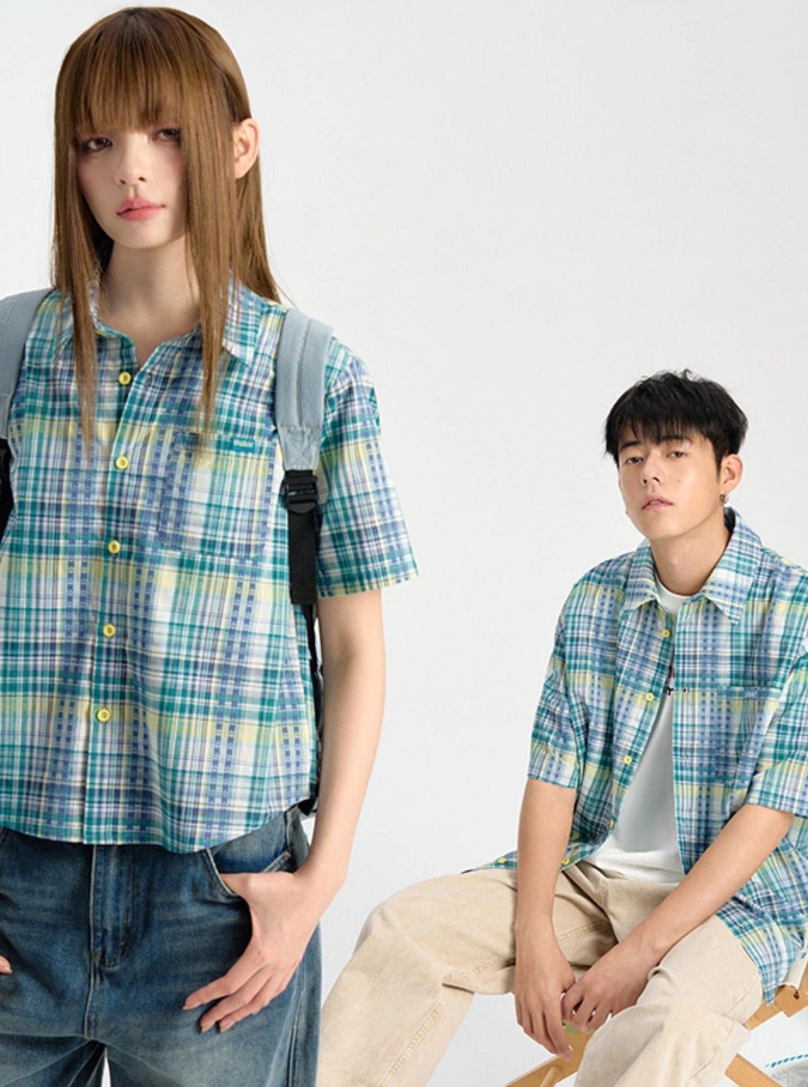 Cropped blue plaid short sleeve shirt styled with denim jeans and a backpack in a contemporary Korean fashion look