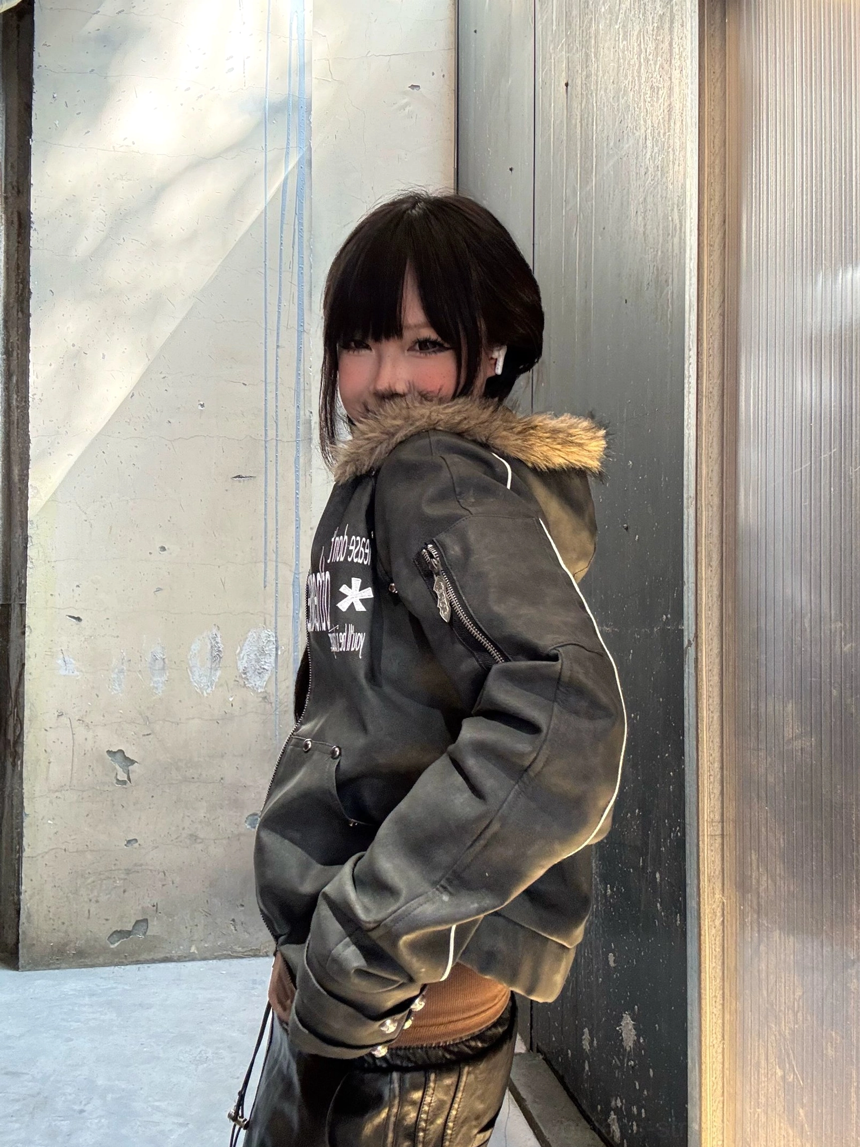 Side view of a cropped faux fur hood jacket with graphic front details and contemporary avant-garde streetwear silhouette