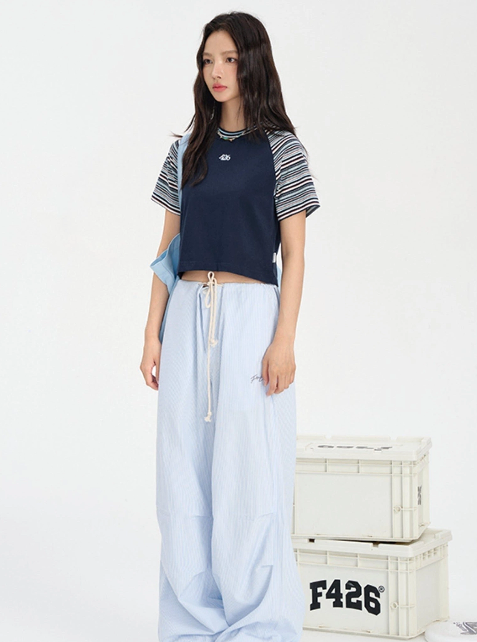 Cropped striped raglan baby tee with embroidered chest detail for Seoul streetwear outfits