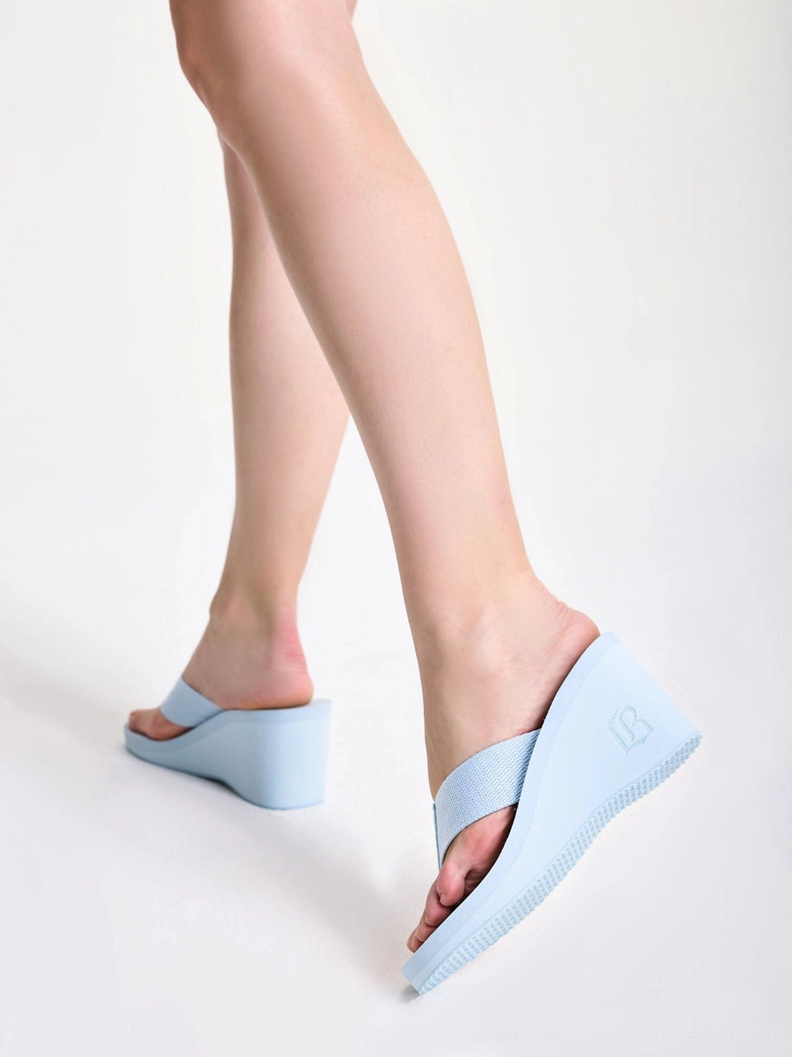 Cushioned wedge platform flip-flops for women with wide thong strap and textured tread in a modern streetwear silhouette
