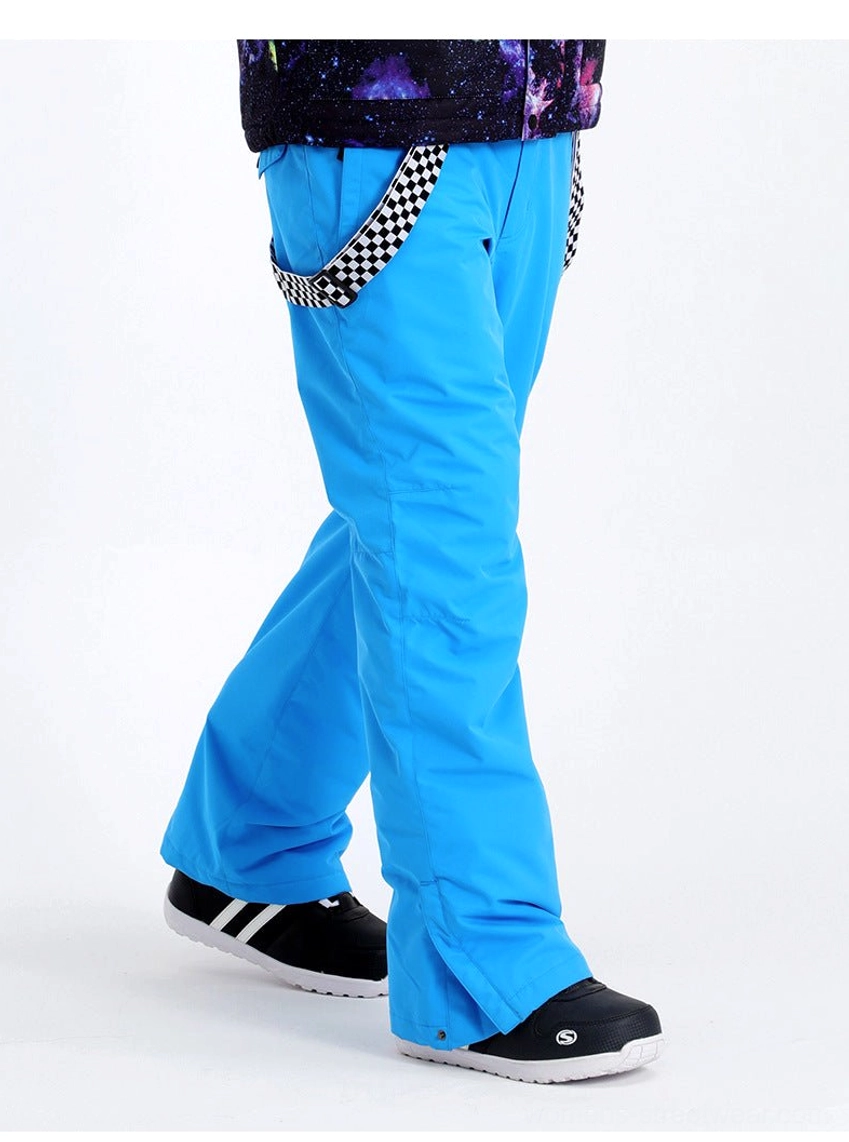 Model wearing cyan blue checkerboard strap snow pants with black sneakers in a casual outdoor streetwear outfit