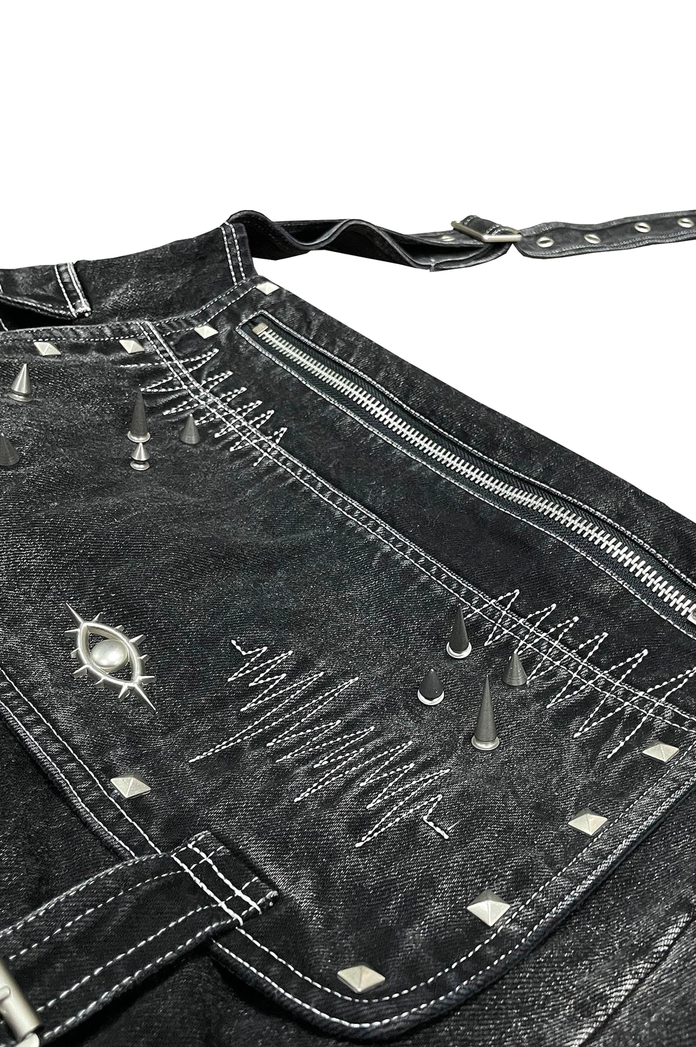 Ultra close-up craftsmanship detail of cyberpunk denim crossbody bag flap with zipper eye metal badge rivets and precise topstitching