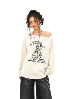 Dalmatian graphic off-shoulder oversized long sleeve tee in apricot beige styled with black wide-leg jeans front full-body view