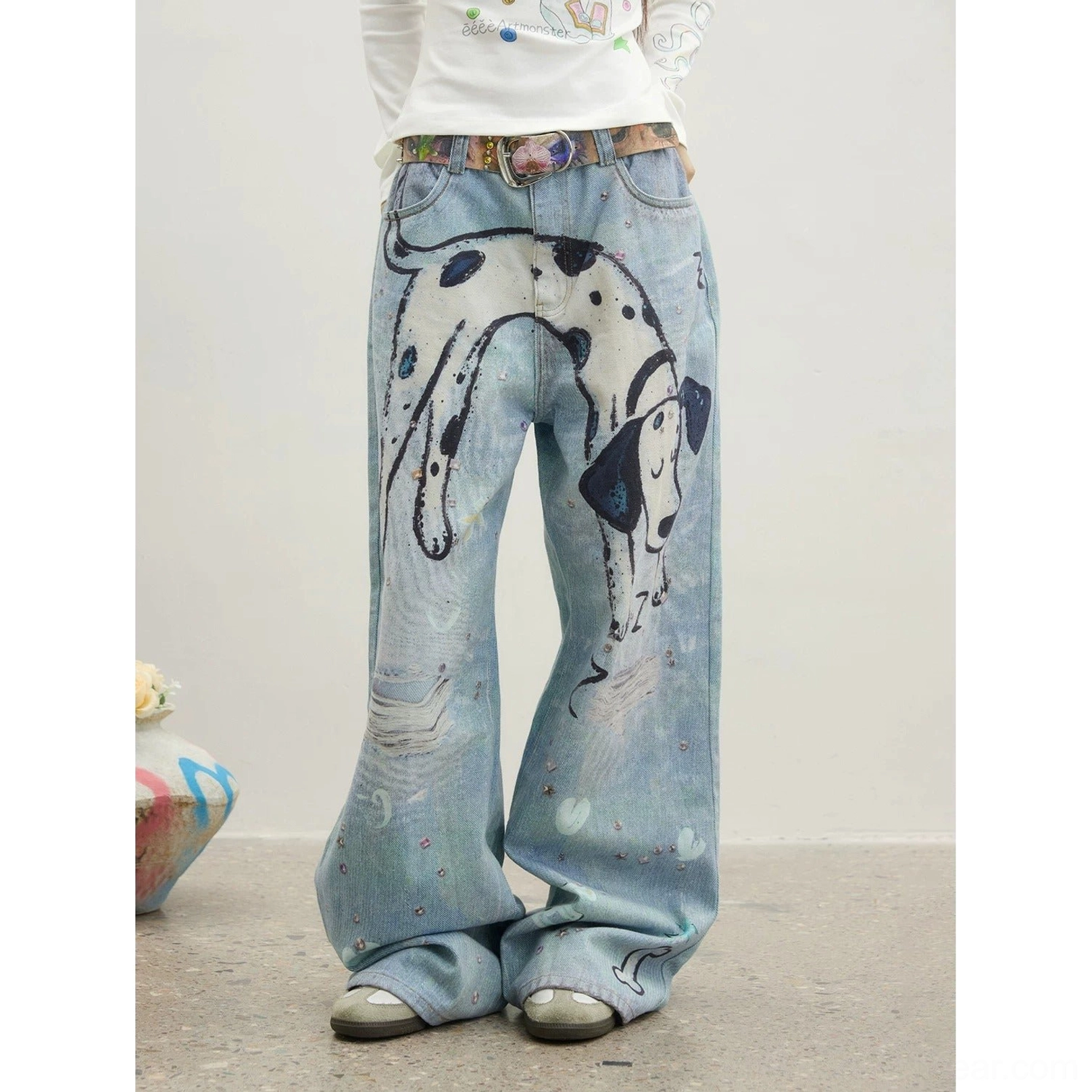 Close-up view of relaxed full-length dalmatian graphic jeans showing loose straight-leg silhouette, clean hem, washed blue denim, and subtle decorative details