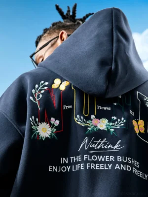 Close-up rear view of a Dark Blue oversized floral embroidered zip-up hoodie showing detailed flowers butterflies and statement back lettering