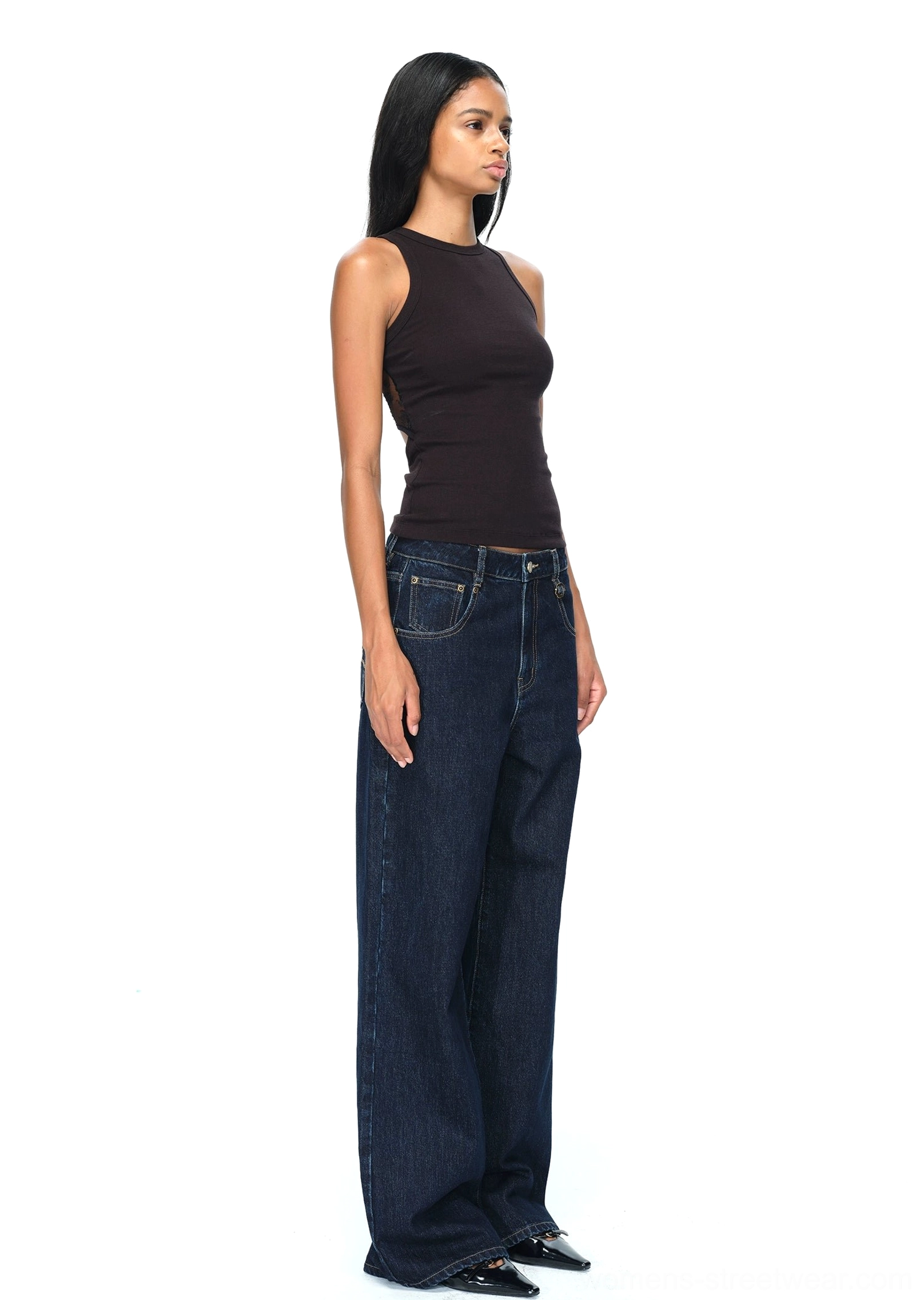 Close-up view of dark blue wide-leg jeans back pocket with contrast gold embroidery and precise stitching