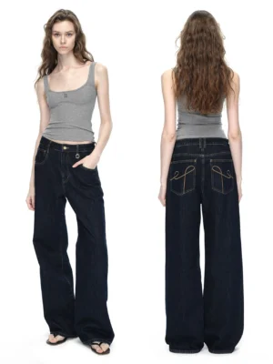 Front three quarter view of dark blue raw denim wide-leg jeans with high waist and relaxed streetwear silhouette