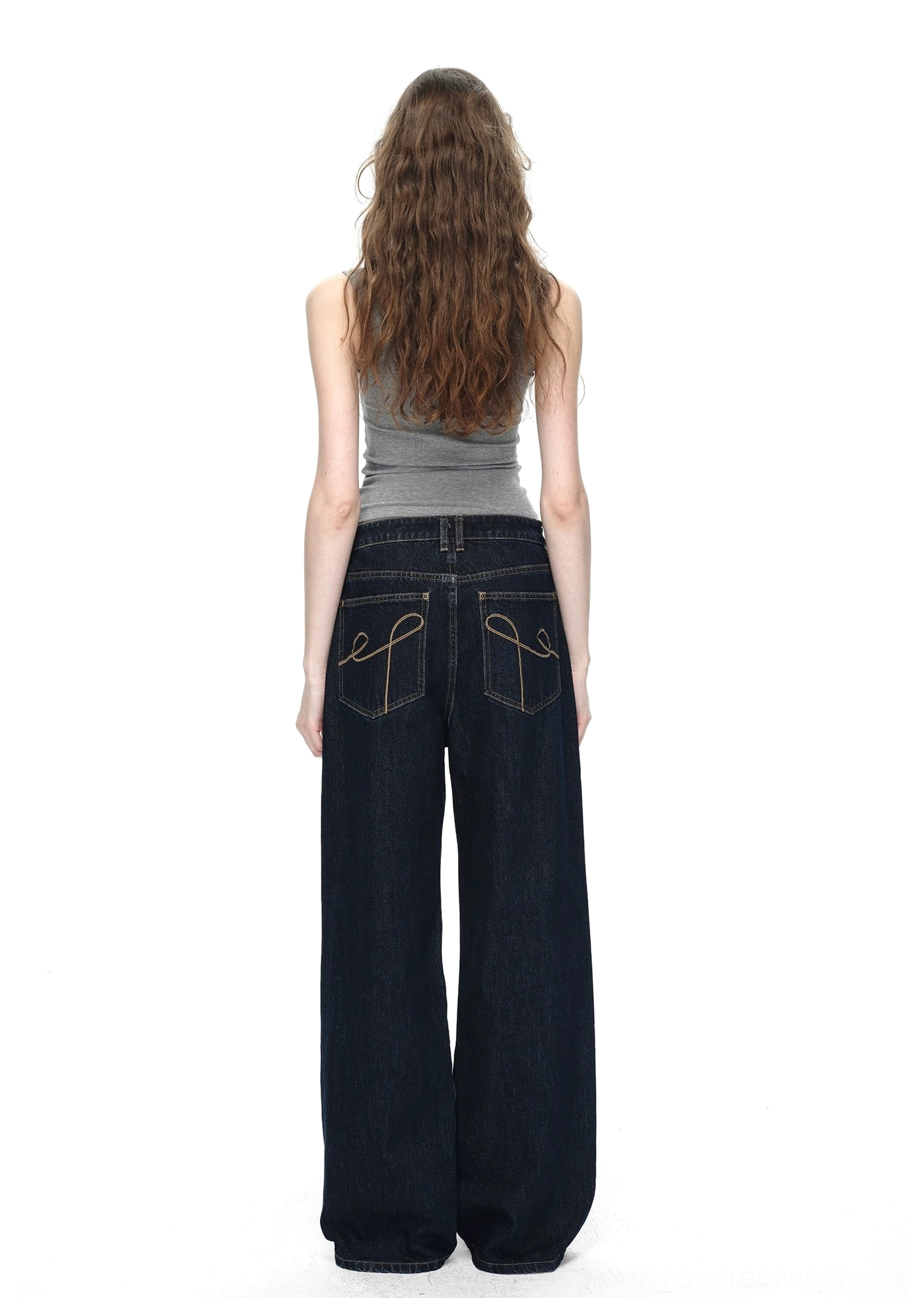 Back full-body view of dark blue raw denim wide-leg jeans with matching embroidered back pockets