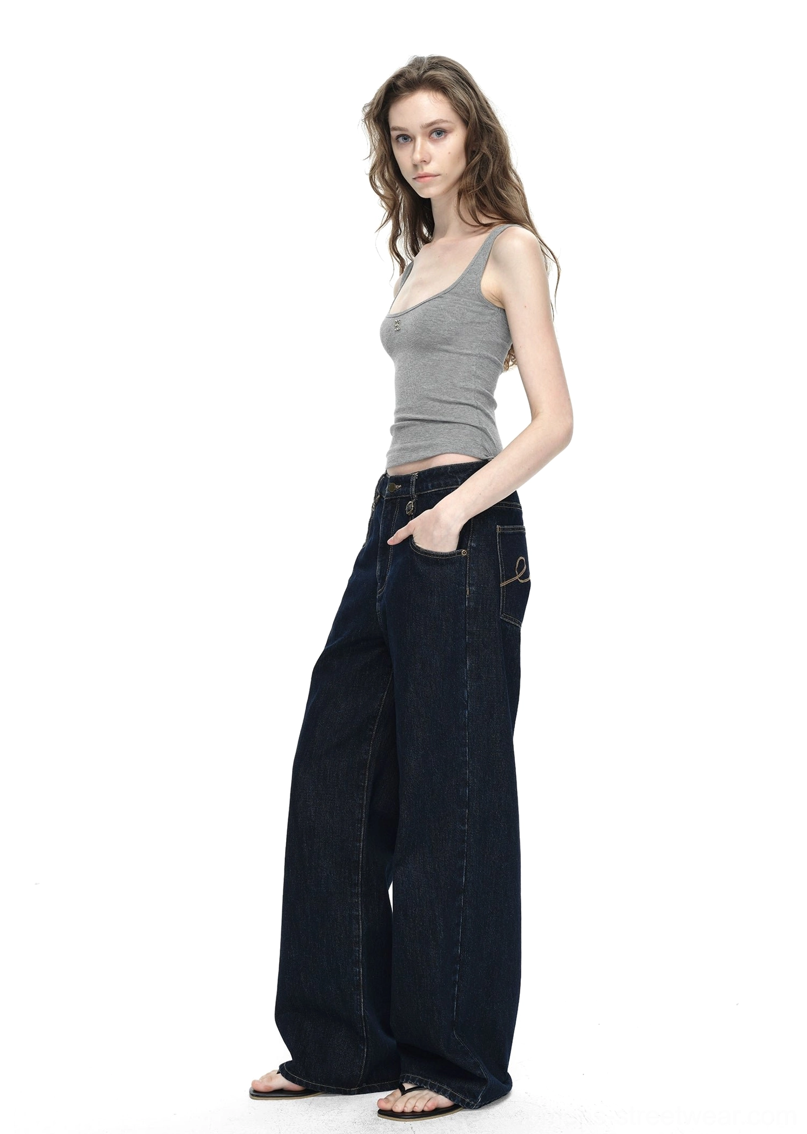 Dark blue raw denim wide-leg jeans with minimalist finish, structured leg shape, and versatile styling potential