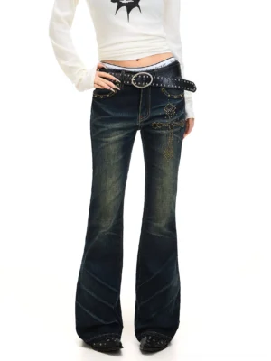Front detail of dark blue Y2K flared jeans showing the sparkling cross rhinestone embellishment and contrast stitching