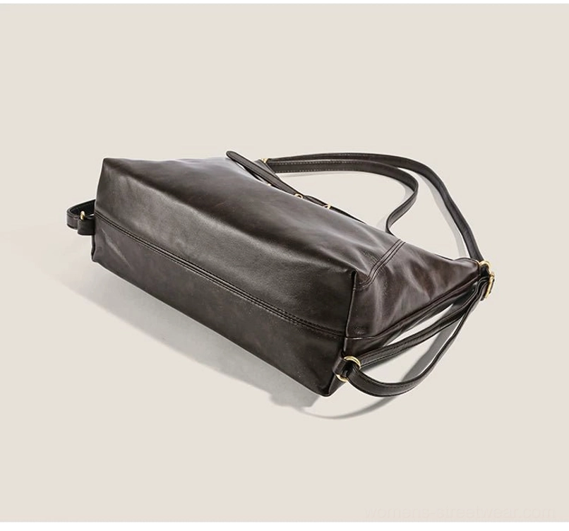 Dark brown buckle hobo bag shown from a bottom side profile with rounded base, gold-tone base hardware, and multifunctional convertible strap system